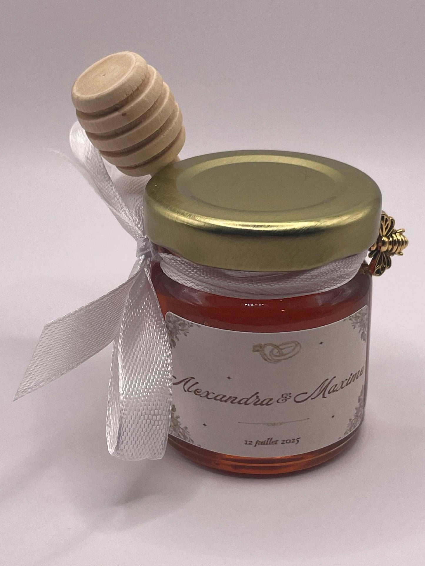 Petit pot de miel personnalisé pour mariage avec étiquette Alexandra & Maxime, ruban blanc et cuillère en bois