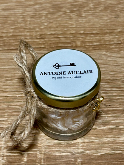 Mini pot en verre rempli de bonbons au miel artisanaux avec nœud en ficelle de jute et étiquette personnalisée Antoine Auclair Agent Immobilier.