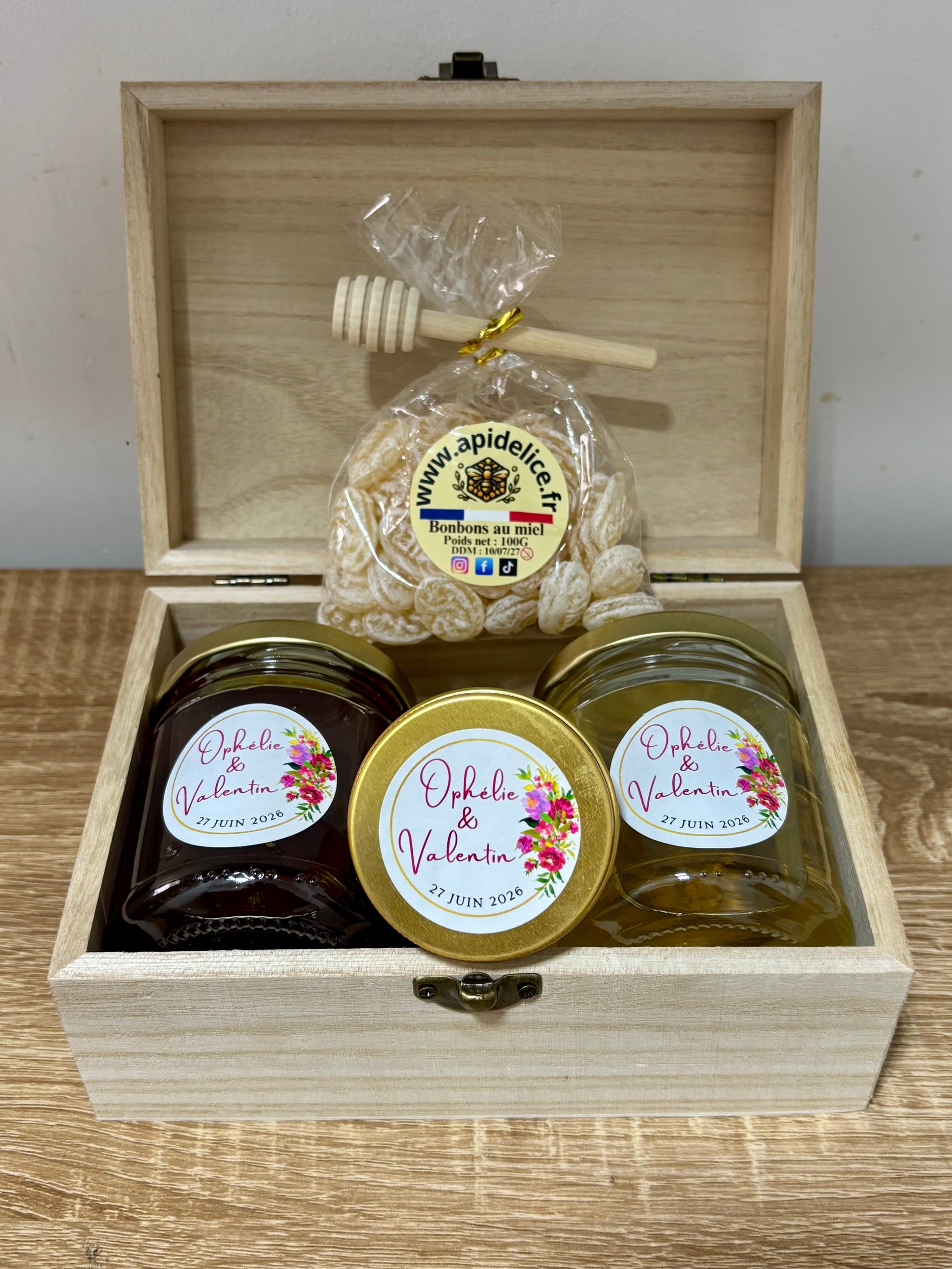 Coffret cadeau en bois personnalise Apidelice contenant deux pots de miel, un sachet de bonbons au miel et une bougie en cire d'abeille